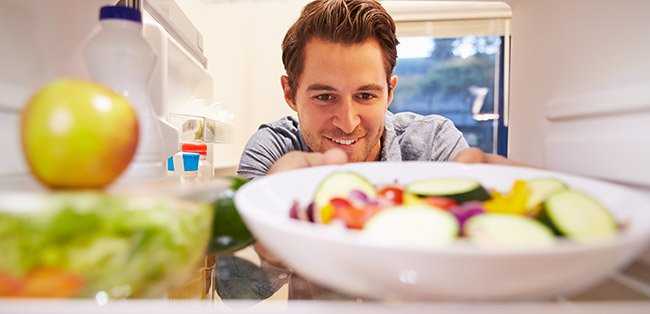 Homem a tirar comida do frigorífico