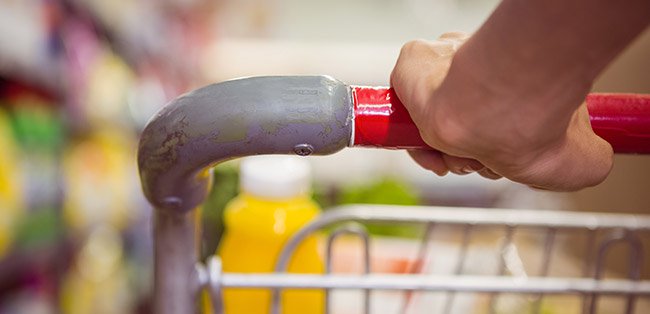 Mão a segurar carrinho de compras no supermercado
