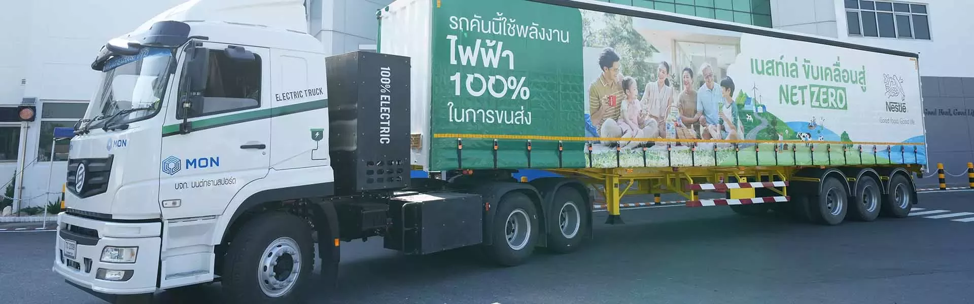 Camião elétrico da Nestlé estacionado junto a um centro de distribuição, promovendo o compromisso da empresa com a logística 
