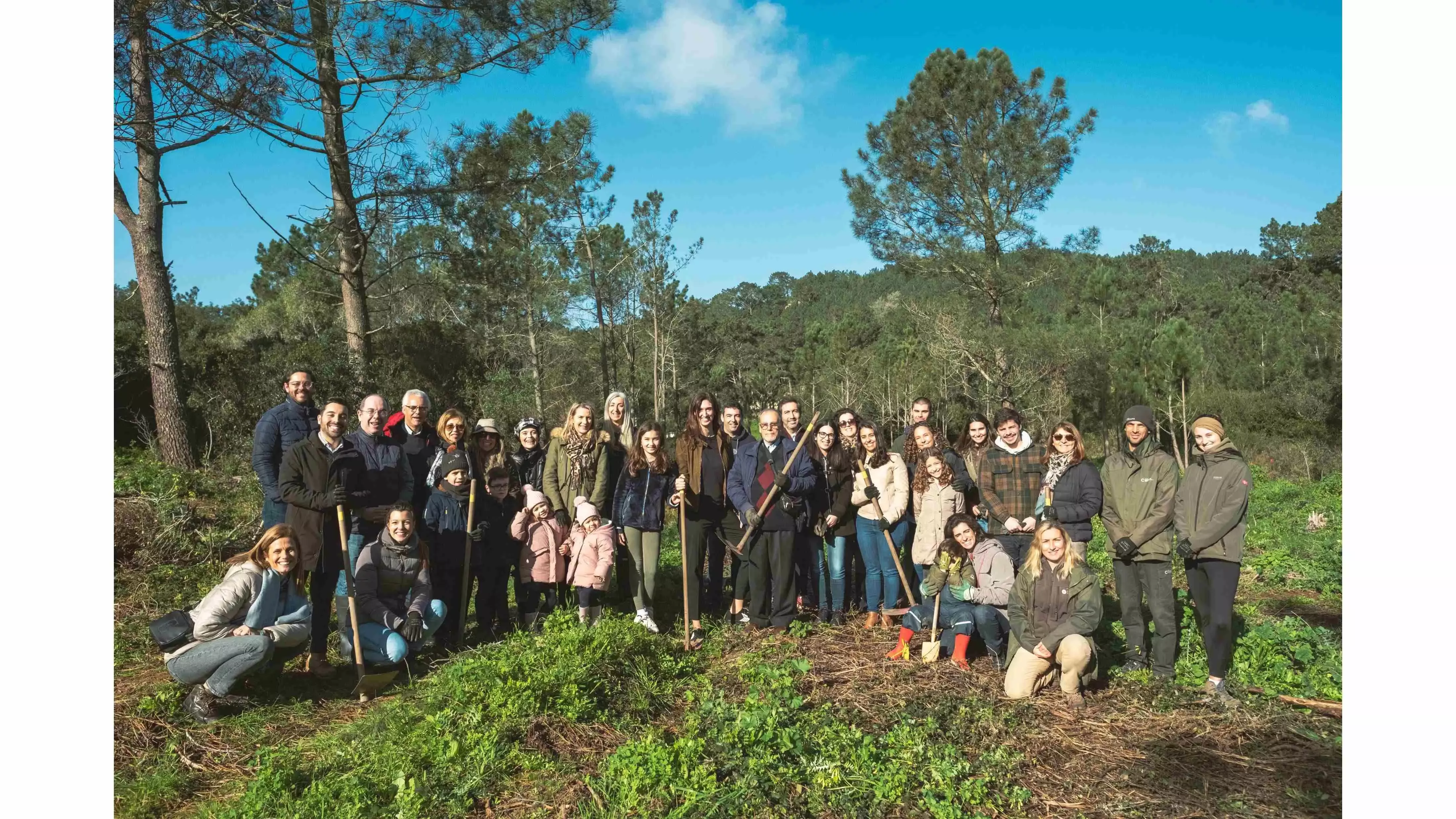 Colaboradores Nestlé e crianças prontos para plantar árvores