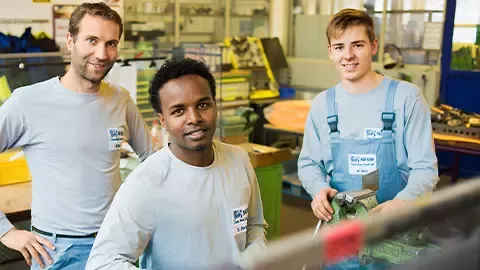 "Jovens participantes num programa de formação prática numa oficina industrial.