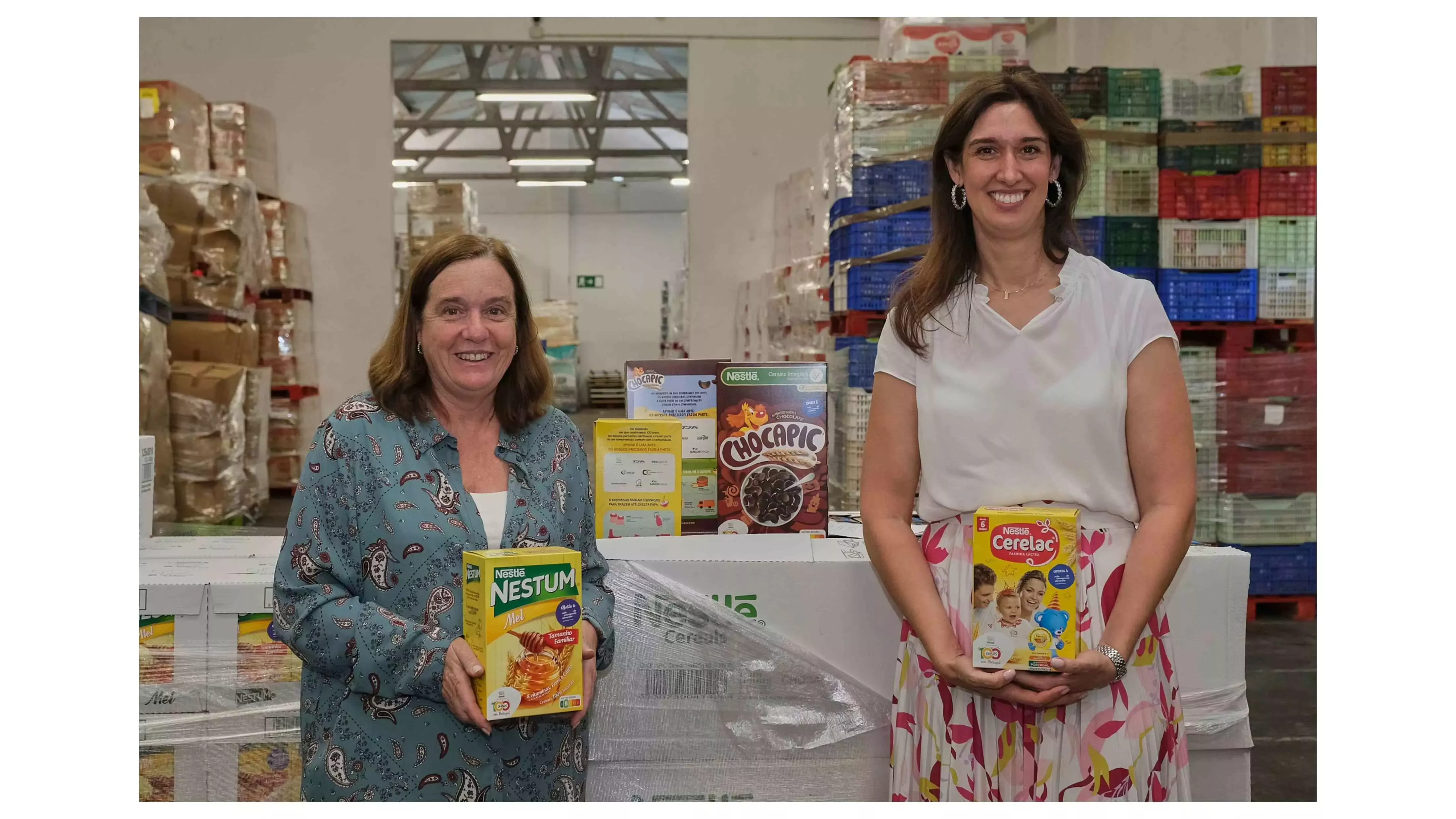 Isabel Jonet e Anna Lenz no armazém do Banco Alimentar com embalagens de NESTUM, CERELAC e CHOCAPIC