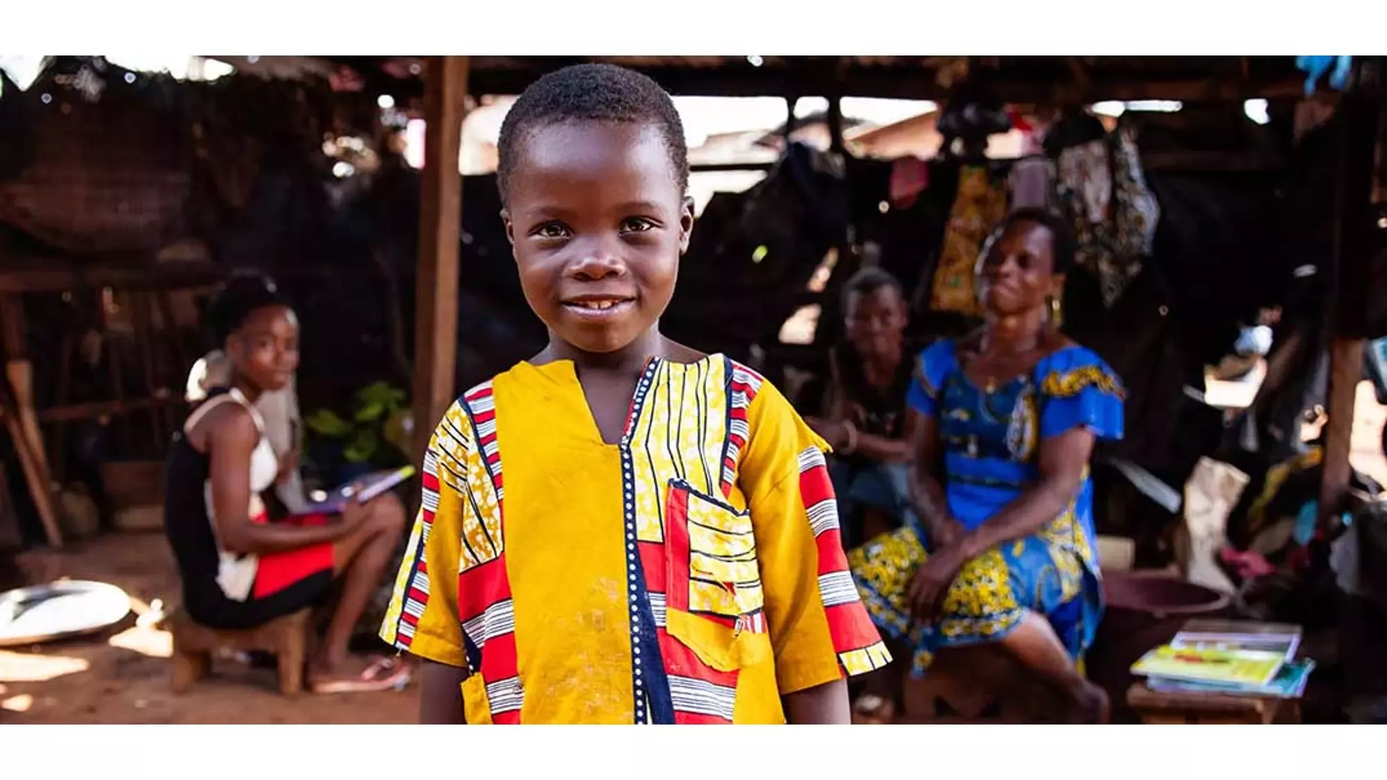 Menino africano com a família a sorrir para a câmara