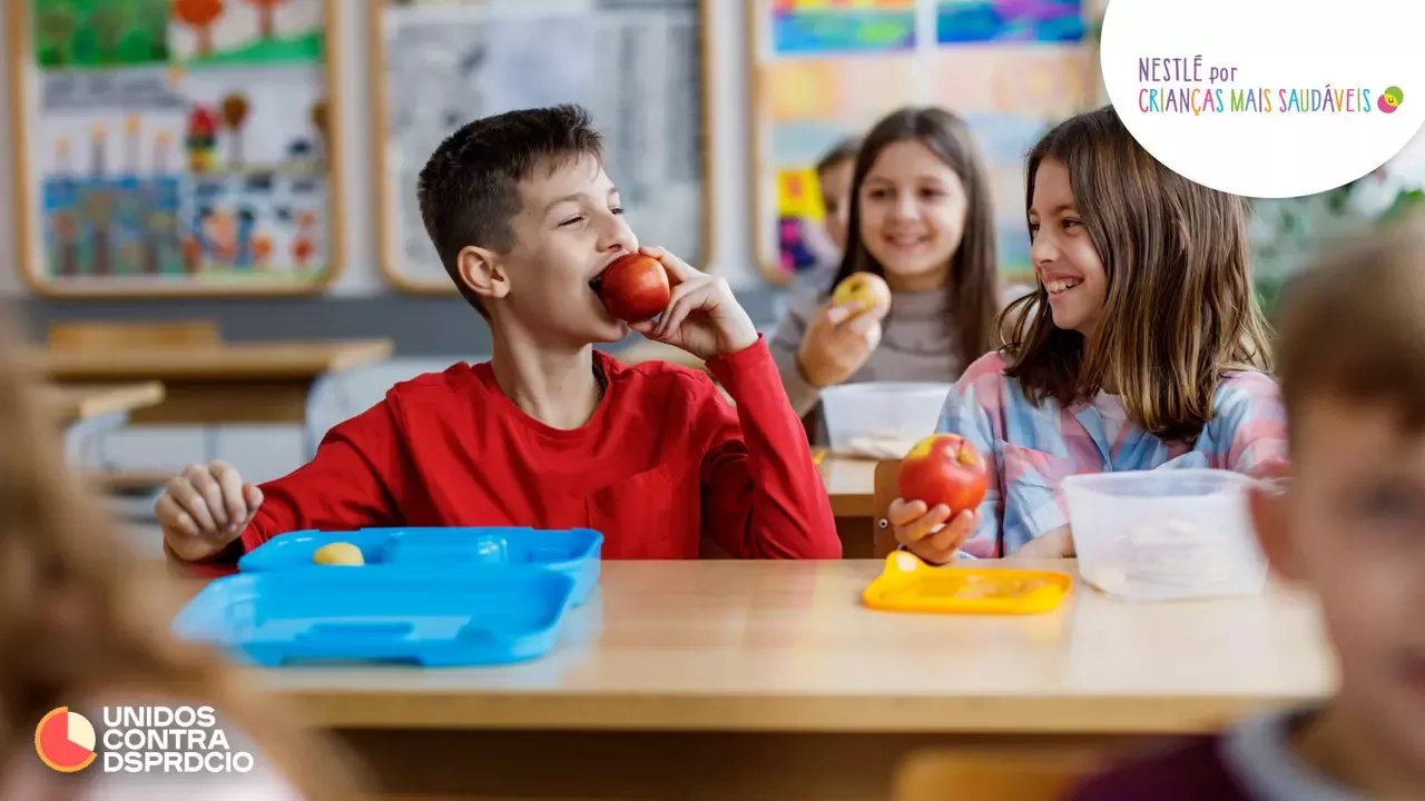 Crianças comem fruta em sala de aulas