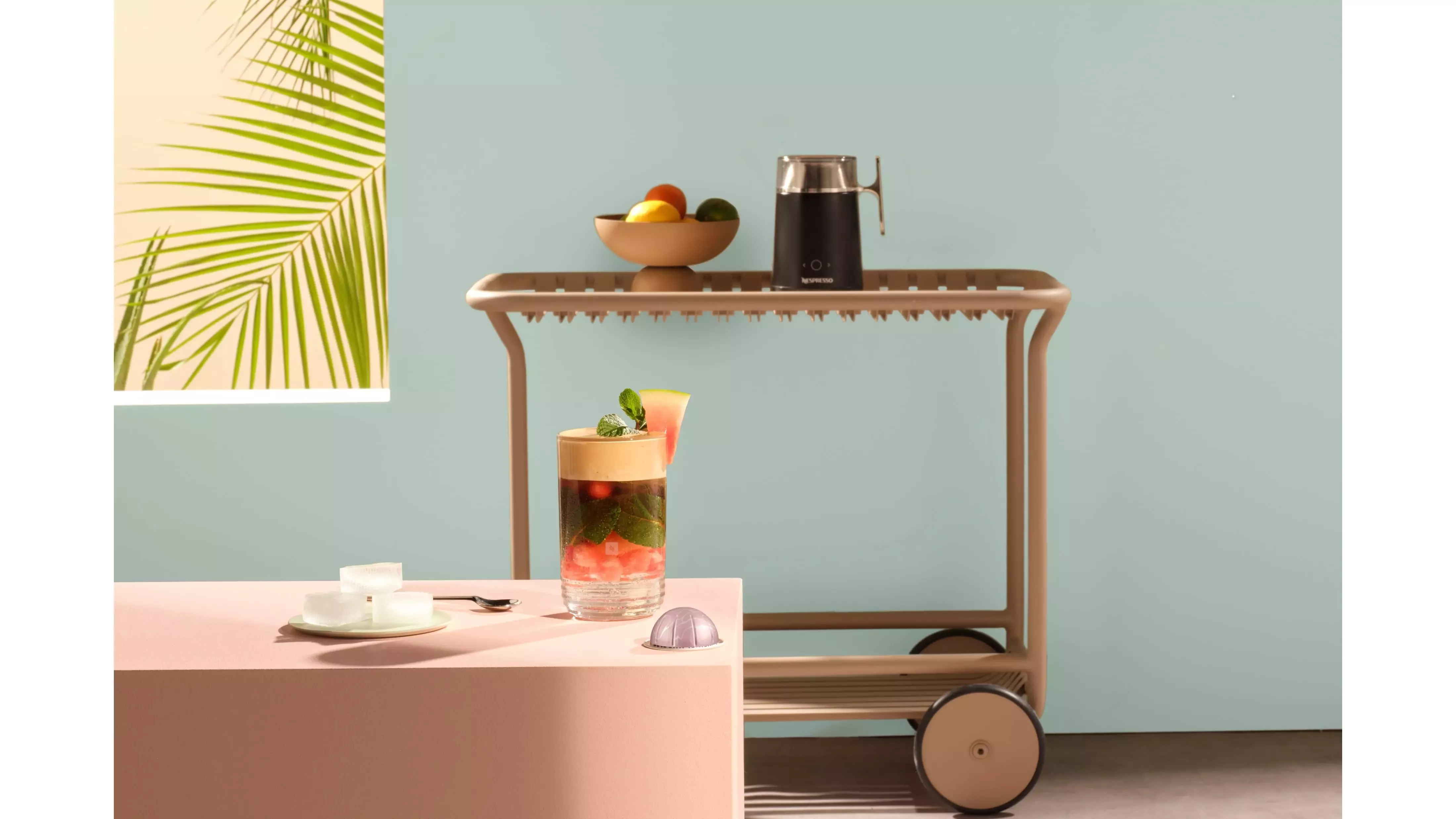 Copo com Juicy Watermelon Fizz em mesa rosa de uma sala