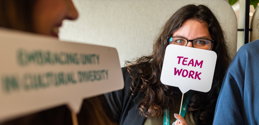 colaboradora com uma placa "team work"